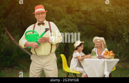 The Good-looking Old Man And His Family In The Garden Stock Photo