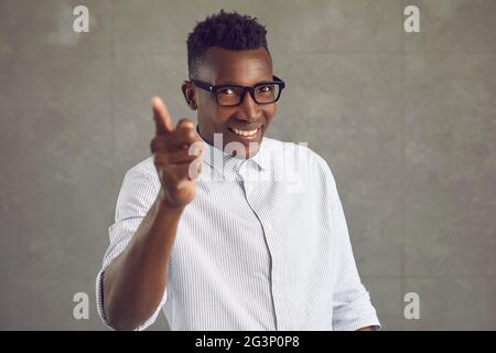 Happy handsome black man smiling and doing You're Right gesture isolated on gray background Stock Photo