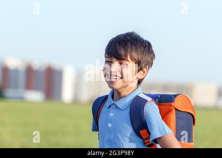 Portrait of happy boy with backpack, school child waiting for school bus, primary school student, on the way to school Stock Photo