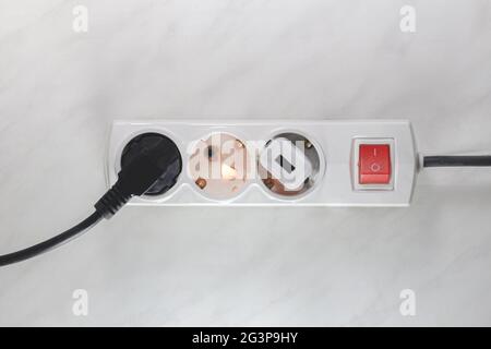 Failure caused by burning of the wire cable and socket outlet plug in the house, blurred photo, concept blurred background, selective focus. Stock Photo