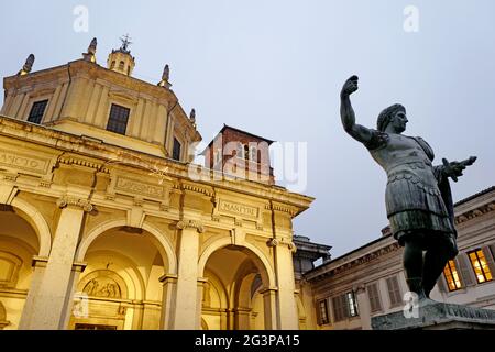 The statue of the Roman emperor Constantine and Saint Lorenzo roman Church illuminated at night, in Milan. Italy. Stock Photo