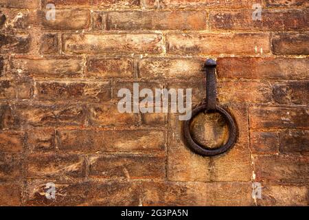 A rusty metal ring embedded in a red brick wall. Copy space for text Stock Photo