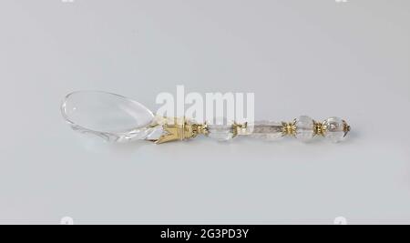 Spoon of ground rock crystal with gold-plated silver. Spoon of a table cutlery consisting of knife, fork and spoon, of ground rock crystal, mounted in lines on double, decorated gold-plated silver rosettes. Stock Photo