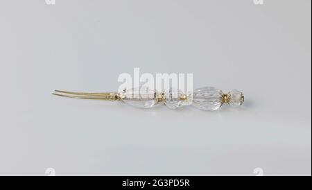 Fork of ground rock crystal with gold-plated silver. Fork, part of a table cutlery consisting of fork, knife and spoon, of ground rock crystal, mounted in sections on double, decorated gold-plated silver rosettes. Stock Photo