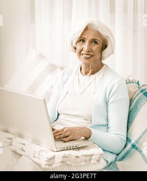 Happy Grandmother Using Computer Technologies In Laptop Stock Photo