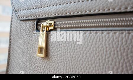 Natural or artificial leather texture. Fragment of a beige or powdery bag with a zipper and stitching. Zipper or clasp bag design element. Bovine skin Stock Photo