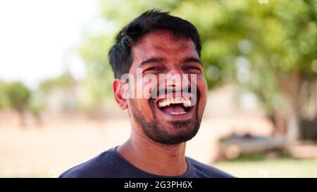 Portrait of very excited young Indian bearded man, celebrating victory with laughing and screaming. Stock Photo