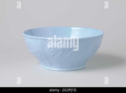 Bowl, blue, with on the outside of the wall embossed six onion-shaped cartouches with flowers. Bowl of bluestone, with six UI-shaped cartouches with flowers on the outside of the wall with flowers against a matted soil. Stock Photo