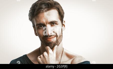 Bearded Man Looks At Camera Touching Chin With Hand Stock Photo