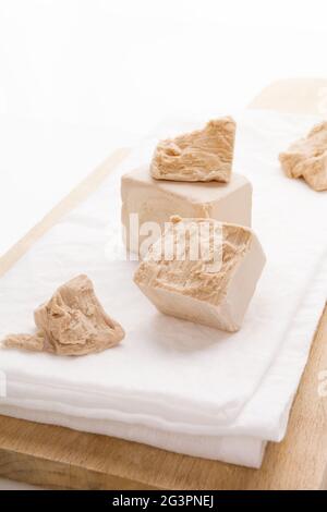 Fresh yeast blocks on wooden board. Stock Photo