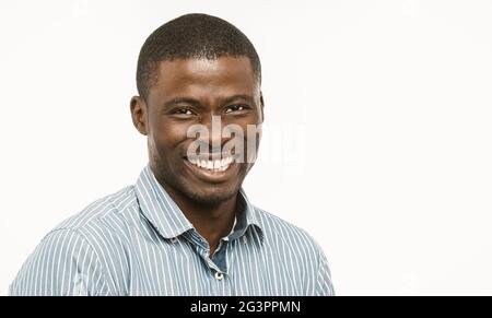 Handsome African guy with white-toothed smile looking at camera, dark-skinned well-dressed young man cut out on white background Stock Photo