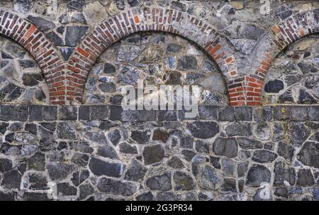 Old quarry stone wall with brick ornaments Stock Photo