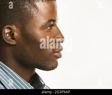 Serious African american man looks confident. Close up profile of Attractive Dark-skinned guy isolated on white background. Copy Stock Photo