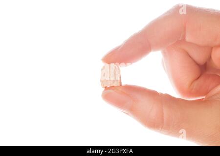 Ecstasy pill in a woman's hand isolated on white background. Stock Photo