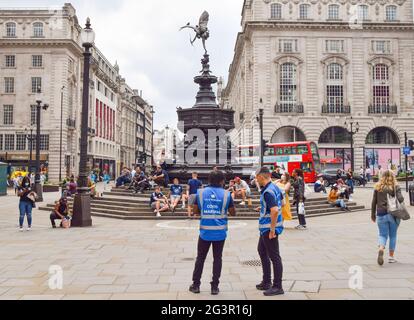 COVID-19 marshals on patrol in Piccadilly Circus, London.England is seeing a huge rise in coronavirus cases, which scientists say is driven by younger people who have yet to be vaccinated, along with the rapid spread of the Delta variant. Stock Photo