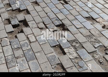 Old damaged cobbled road, concrete street pavement, abstract background photo Stock Photo