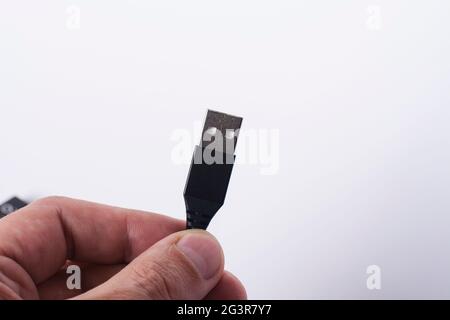 Businessman hand holding black usb cable connection wire on white background with copyspace Stock Photo