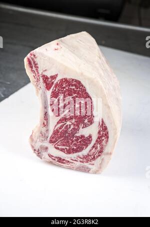 Raw dry aged wagyu cote de boeuf beef block as closeup on white board Stock Photo
