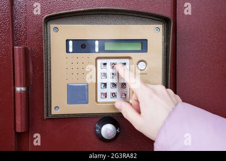 Female finger pushing buttons of intercom, close up view, Caucasian person Stock Photo