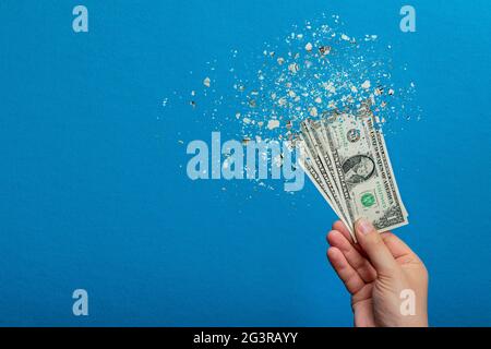 Inflation, dollar hyper inflation. Banner with blue background. One dollar bill is sprayed in the hand of a man on a blue background. Price rise conce Stock Photo