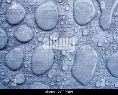 Raindrops on a blue tablecloth kinked Stock Photo