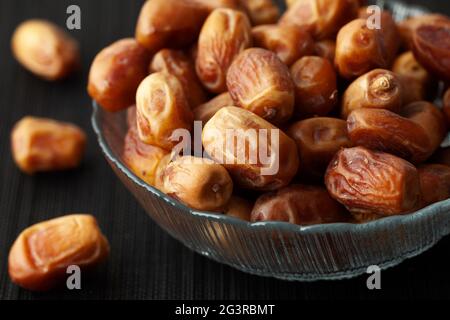 Dried dates in a glass bowl. Low key. Close up. Stock Photo
