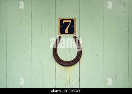 Lucky horseshoe and lucky number seven on street door Stock Photo