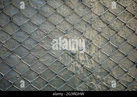 Texture of gray painted wall is reinforced with steel wire mesh. Stock Photo