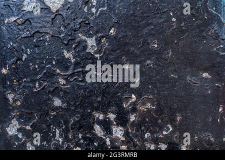 Grunge corroded metal surface with black paint peeling off and rust patterns Stock Photo