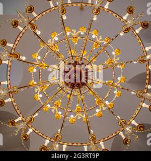 A chandelier from bottom view with colorful ceiling as background Stock Photo