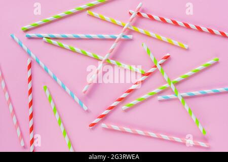 Drinking straws for party on pink background. Top view of colorful paper disposable eco-friendly straws for cocktails. Flat lay. Stock Photo