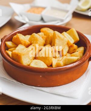 Plate of Spanish style patatas bravas with spicy sauce Stock Photo