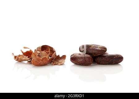 Fresh roasted cocoa beans and peels isolated on white background. Stock Photo