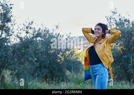 Woman smiling with hands in hair. She is outside. Stock Photo
