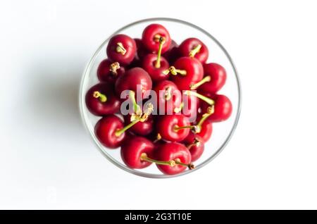 ripe cherry in a glass on a light background, free space Stock Photo