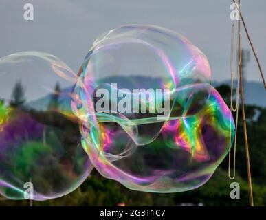 Iridescent soap bubbles floating in a cloudy evening sky Stock Photo