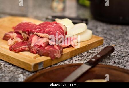 Fresh, sliced red meat on a wooden cutting board. Close up. Stock Photo