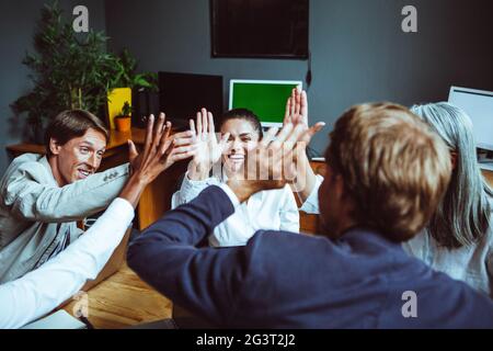 Business people giving each other high five and clapping. Business team celebrating success. Stock Photo