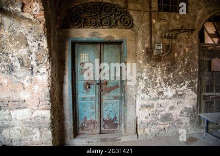 Old blue door of a abandoned house. Old door design. The rear entrance to the castle. Vintage door of old building. Traditional Stock Photo