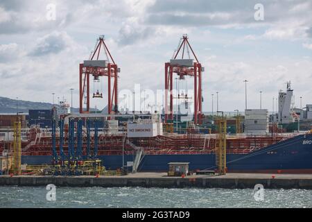 Large industrial cranes loading container ship in Dublin Port in Ireland Stock Photo