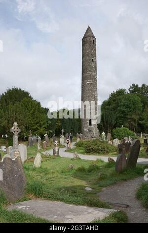 Stone round tower and some ruins of a monastic settlement originally built in the 6th century Stock Photo