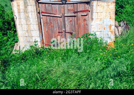 Wooden door of old cellar . Wine store from ancient . Abandoned antique construction Stock Photo