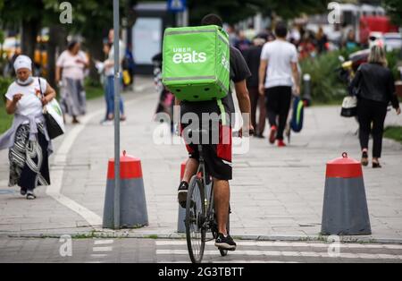 Bucharest, Romania - June 08, 2021: An Uber Eats food delivery courier delivers food in Bucharest, Romania. Stock Photo