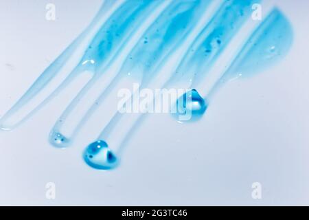 Squeezed cosmetic clear cream gel texture Iisolated on white background. Close up transparent serum drop