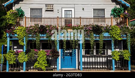 Lots of flowers on the balcony and in pots at Tangled Up in Blue Restaurant on Bench St., Taylors Falls, Minnesota USA. Stock Photo