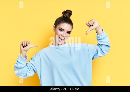 Young happy wman pointing to herself isolated over yellow background Stock Photo