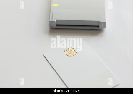 A white plastic card and a personal data reader. Theft or leakage of confidential information. layout with copy space Stock Photo
