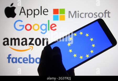 In this photo illustration, the EU (European Union) flag is seen on a smartphone screen in front of Apple, Microsoft, Google, Amazon and Facebook logos. Stock Photo