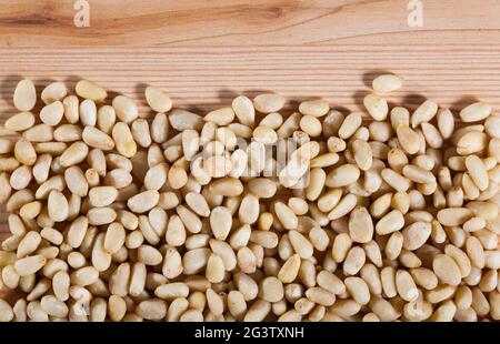 Pine nuts scattered on wooden surface Stock Photo