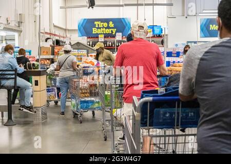 Sam's Club membership warehouse store customers wait in line with their purchases to have shopping carts checked in order to to exit the store. (USA) Stock Photo